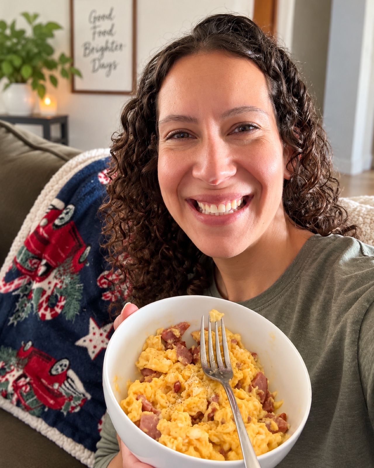 Bekah at home, smiling with a bowl of eggs and meat